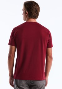 Rode katoenen T-shirt met een crewneck en korte mouwen. Gladde textuur, geen zichtbare patronen of hardware, en een rechte zoom.