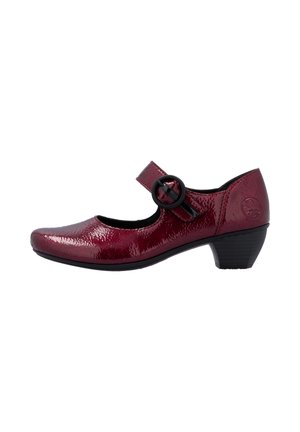 Chaussure Mary Jane rouge foncé brillante avec bout arrondi, petit talon noir et bride circulaire noire à boucle sur fond blanc.