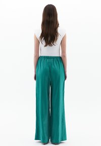 Teal wijde broek met een elastische tailleband, gemaakt van een gladde, lichte stof. Heeft een losse pasvorm en geen zichtbare patronen of accenten.