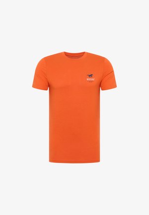 Kurzärmliges, orange T-Shirt aus Baumwolle mit einem blauen Mustang-Logo auf der linken Brustseite, mit einem Rundhalsausschnitt und normaler Passform.