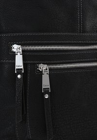 Borsa in pelle nera texture con due zip in metallo argentato, ognuna con un tirante inciso con il nome del marchio "Gabor."