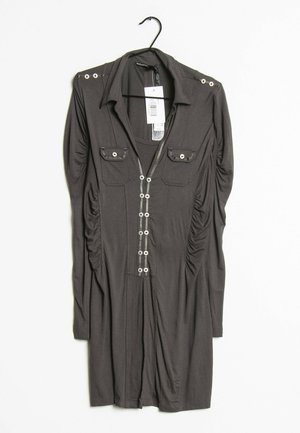 Sukienka z długim rękawem w ciemnoszarym kolorze, z guzikami z przodu i na ramiączkach, dwie kieszenie na piersi, zawieszona na czarnym wieszaku z metkami.