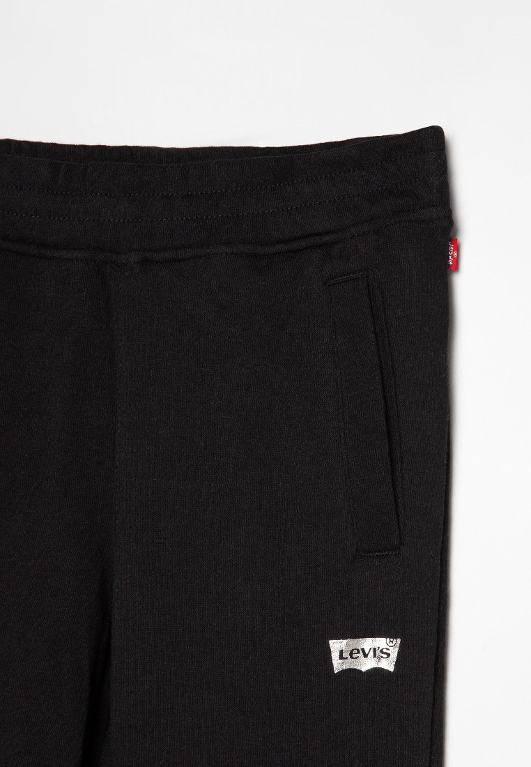 Pantalons de jogging en coton noir avec une taille sans couture, une poche latérale et une étiquette en argent Levi's en bas à gauche. Texture douce et design classique.