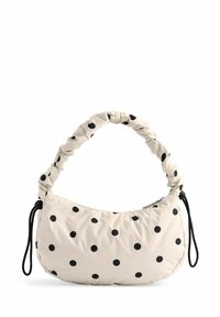 Beige dot-mønstret håndtaske med en samlet hank, lavet af blødt stof, med lynlåslukning og sorte detaljer.