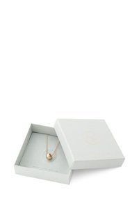 Collar de color dorado con un colgante esférico, presentado en una caja de regalo texturizada de color gris claro con un logo en relieve y un forro interior suave.