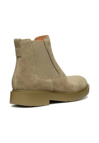 Stivale alla caviglia in suede beige con pannelli laterali elasticizzati, punta arrotondata e suola in gomma. Presenta un linguetta sul retro per una facile calzata.