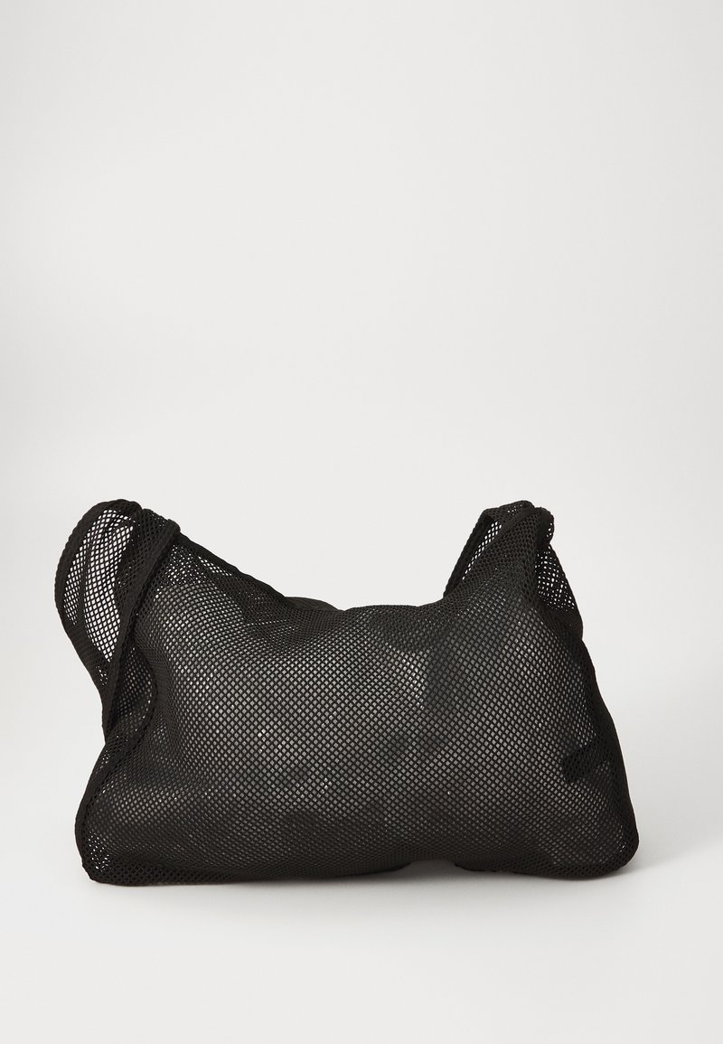 Sac en maille noire avec une surface douce et texturée et une forme arrondie. Équipé de deux poignées et d'un intérieur spacieux. Design léger et respirant.