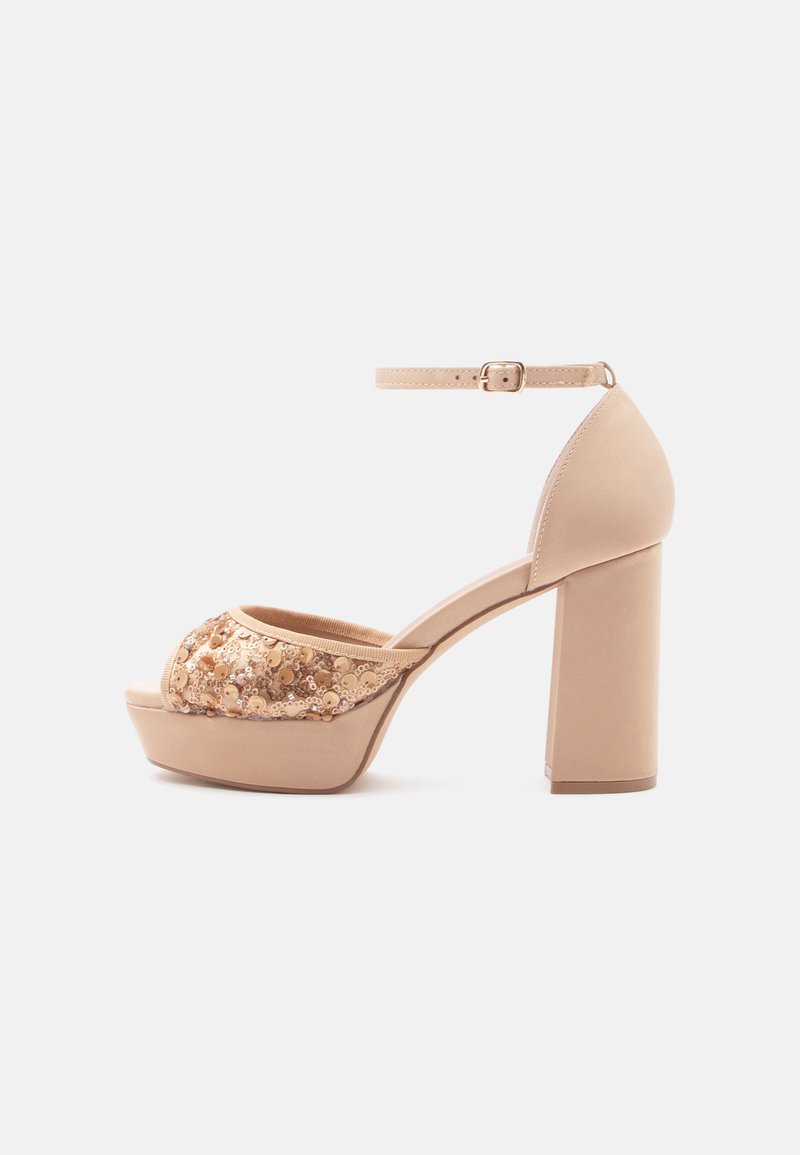 Nude platform sandalen met een chunky hak, open teen en een textured beige bloemen gestikte band. Enkelsandaal met een gespsluiting.