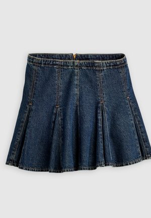 Temno modra denim mini krilo z gubami in zadnjim zadrgo, prikazano na enostavni svetlo sivi podlagi.