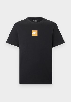 Črna Nike majica s kratkimi rokavi, na sredini prsnega koša ima majhen oranžen kvadratni logotip in bel Nike znak Swoosh.
