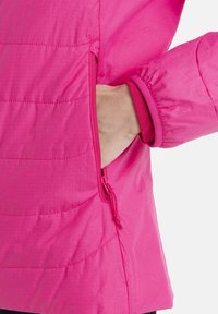 Růžová zateplená bunda s prošívanou strukturou, bočním zipovým kapsou a elastickými manžetami. Lehký materiál s hladkým povrchem.