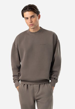 Brauner Sweatshirt mit Rundhalsausschnitt, langen Ärmeln und gerippten Bündchen. Verfügt über ein dezentes Logo auf der Brust und eine lässige Passform.