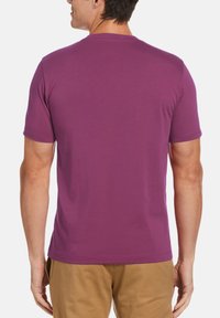 Short-sleeve t-shirt in solid purple, made of soft fabric. Features a crew neck and a straight hem, with a relaxed fit.