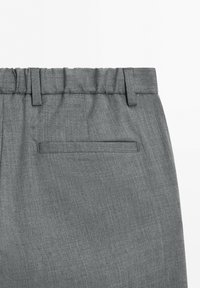 Graue Stoffhose mit elastischem Bund, Gürtelschlaufen und einer einzelnen horizontalen Gesäßtasche auf weißem Hintergrund.