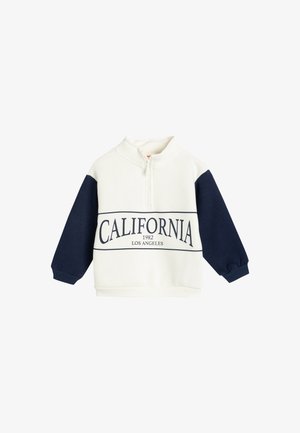 Witte en marineblauwe sweatshirt met een halve ritssluiting en de opdruk "CALIFORNIA 1982 LOS ANGELES" in vette letters over de voorkant.