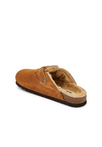 Pantofole in suede marrone con fodera in pelliccia, design slip-on, punta arrotondata e un piccolo bottone decorativo sul lato. Suola testurizzata per una buona aderenza.
