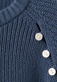 Mornarsko plavi pleteni džemper s rebrastom teksturom, s dva okrugla krem dugmeta na ramenu i okruglim izrezom vrata.
