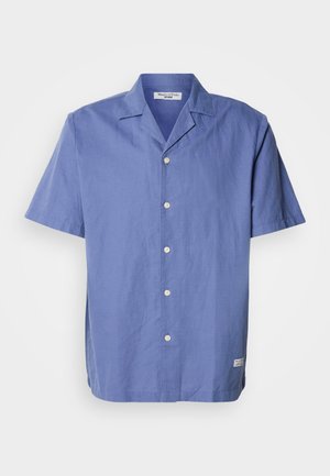Short-sleeve, light blue shirt made of linen with a camp collar, front buttons, and a small label on the side hem. Smooth texture.