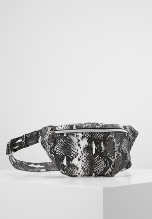 Sac banane à imprimé serpent noir et blanc avec fermeture éclair sur le devant et sangle réglable, présenté sur un piédestal blanc.