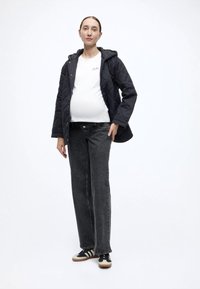 Ναυτικό μπλε μπουφάν με επένδυση και κουκούλα, λευκό μπλουζάκι και γκρίζο τζιν παντελόνι. Μαύρα και λευκά αθλητικά παπούτσια με μπεζ σόλα. Χαλαρή εφαρμογή συνολικά.