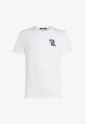 Tricou alb din bumbac, cu mâneci scurte, decolteu rotund și un mic logo negru "KARL" în zona stângă a pieptului. Textură netedă.