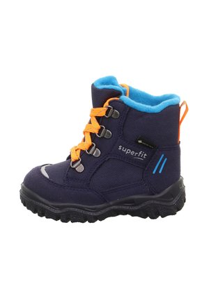 Botte d'hiver pour enfants de couleur bleu foncé avec des lacets orange vif, une doublure en polaire bleue, une semelle noire robuste et une étiquette de marque latérale "superfit".