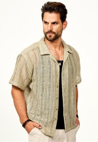 Strickhemd mit kurzen Ärmeln in Beige mit einem strukturierten, offenen Gewebemuster, das eine Kragen-Neckline und einen Knopfverschluss aufweist.