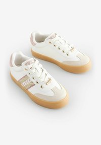Sneakers bianchi con dettagli rosa, caratterizzati da una striscia laterale testurizzata, occhietti dorati, una morbida combinazione di materiali e una suola in gomma.