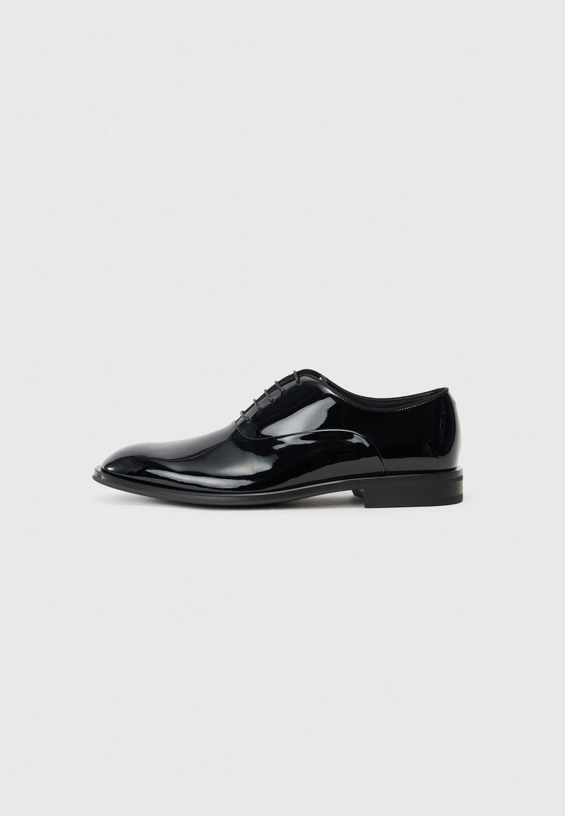 Shoe dress de verniz preto com um design elegante, bico fino e seis passagens para atacadores; superfície lisa e um salto baixo.