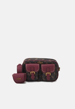 Petit sac bandoulière Guess marron avec poches avant bordeaux et boucles dorées, accompagné d'une petite pochette assortie avec le logo Guess.