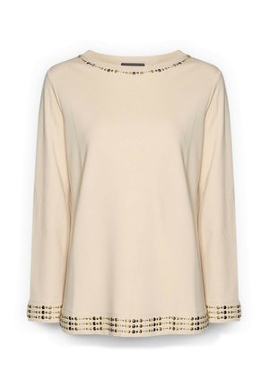 Beige Langarmtop mit rundem Ausschnitt, versehen mit goldenen Akzenten entlang des Ausschnitts und Saums, aus einem weichen Textil gefertigt.