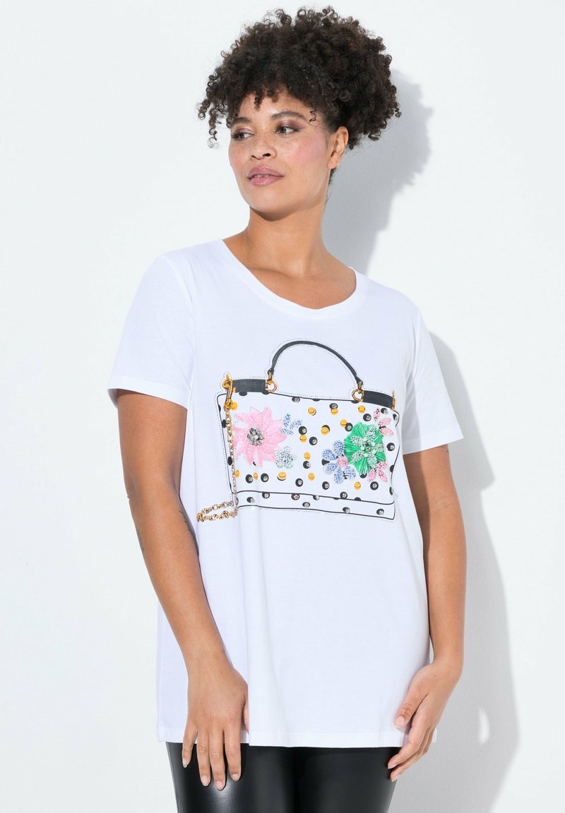 Witte t-shirt met een grafisch ontwerp van een handtas met bloemenpatronen in roze, groen en blauw, verfraaid met gouden en zwarte details.