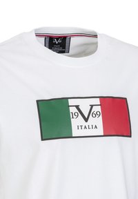 Weißes Kurzarm-T-Shirt mit einem rechteckigen Grafikdesign in Grün, Weiß und Rot sowie dem Text "1969 ITALIA" in Schwarz.