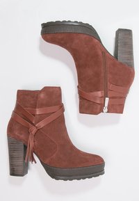 Stivaletti in suede marrone con design a tacco grosso, dotati di una cerniera laterale, cinghie in pelle e tacchi a blocco texture.