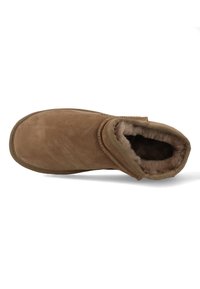 Brown suede ankle boot with a soft interior lining, rounded toe, and a stitched outline. No visible hardware or patterns.