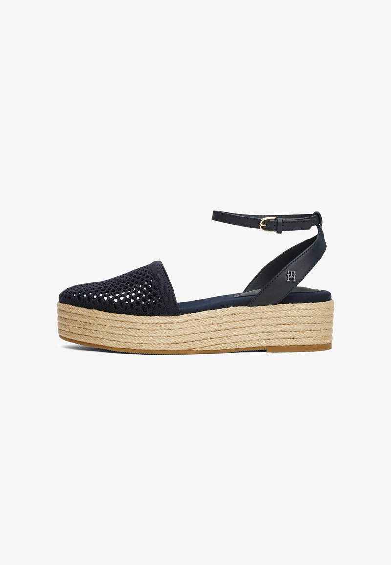 Marineblauwe espadrille wedge sandaal met perforated stoffen bovenwerk, enkelbandje en jute-wikkelde middenzool. Platte rubberen zool voor grip.