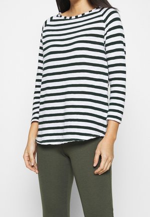 Randig långärmad tröja med mörkgröna och vita horisontella ränder, rund halsringning och lätt rundad fåll, visas tillsammans med olivgröna leggings.