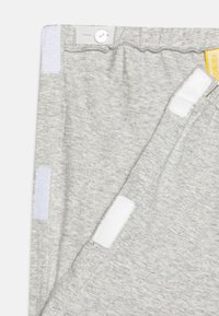 Pantalons de survêtement gris en mélange de coton doux, avec une fermeture à bouton, une taille élastique et des accents en Velcro sur les côtés.