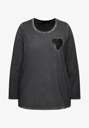Chemise grise à manches longues avec un col rond, ornée d'un cœur en sequins noirs sur le côté gauche de la poitrine et d'un ourlet légèrement courbé. Texture douce.
