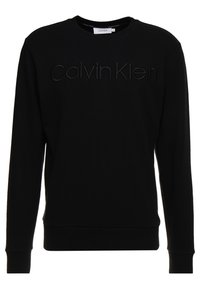 Felpa nera in cotone. Caratterizzata da un colletto rotondo e maniche lunghe. "Calvin Klein" in rilievo al centro. Polsi e orlo aderenti.