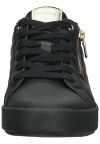 Baskets noires avec une tige en cuir lisse, fermeture à lacets, détail de fermeture éclair dorée sur le côté, et semelle en caoutchouc.