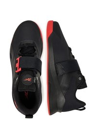 Czarne buty sportowe z czerwonymi akcentami, z teksturowaną cholewką, sznurowaniem oraz paskiem na rzep, i solidną gumową podeszwą.