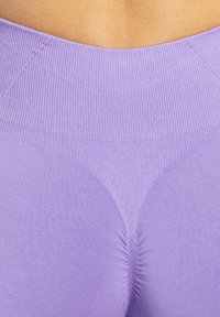 Lila activewear leggings met een geribde tailleband, een soepele textuur en een gebogen stiksel detail rond de bil voor het verbeteren van de vorm.