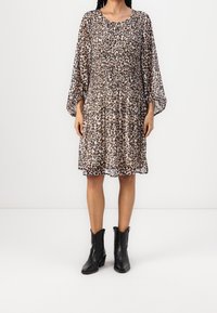 Leopard print dress with long, puffed sleeves, gathered waist, flowing fabric, and a round neckline, paired with black ankle boots.