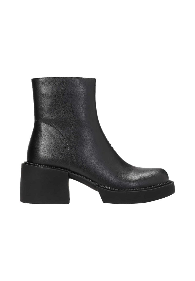 Bottine en cuir noir avec un bout rond, un talon intermédiaire et une texture lisse. Présente un design minimaliste et des coutures contrastantes.