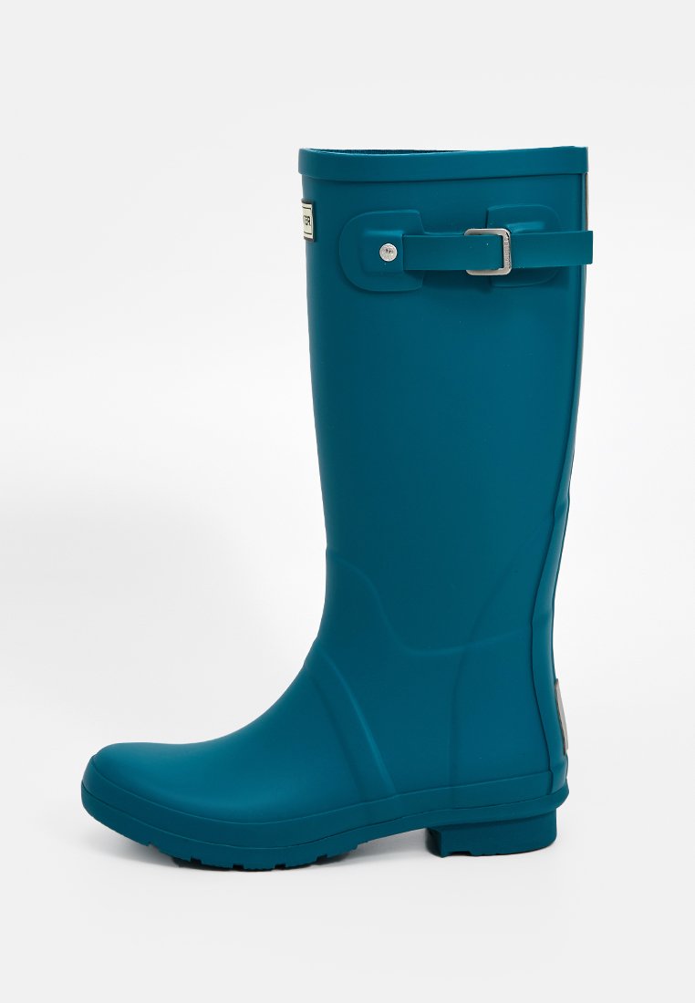 Bota de lluvia alta de goma en color teal con punta redondeada, correa lateral ajustable, diseño limpio y suela texturizada para un mejor agarre.
