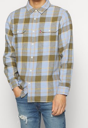 Camisa de cuadros azul y verde oliva con cuello abotonado, dos bolsillos en el pecho y acentos en amarillo claro. Fabricada con tela tejida.