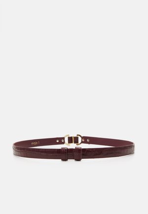 Ciemnobrązowy pasek ze skóry z tłoczeniem w stylu krokodyla, z klamrą w kolorze złotym i regulowanymi dziurkami, ułożony płasko na białym tle.