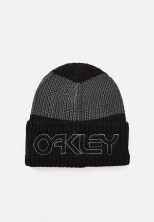 Knit beanie in black and grey with a folded cuff. Features "OAKLEY" embroidered in grey on the front. Textured ribbed material.
