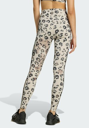 Leggings beige con stampa leopardata nera, design a vita alta, sottili strisce nere laterali e una texture liscia e elastica.